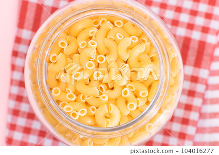 Uncooked Chifferi Rigati Pasta in Glass Jar on Checkered Red Towel Uncooked Chifferi Rigati Pasta in Glass Jar on Checkered Red Towel 104016277