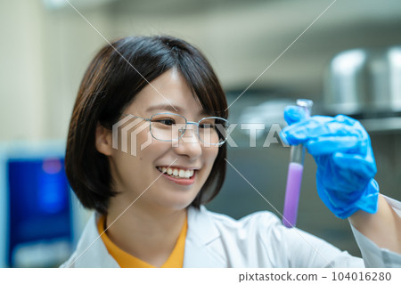 A woman in a white coat doing research A woman in a white coat doing research 104016280