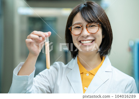 A woman in a white coat doing research A woman in a white coat doing research 104016289