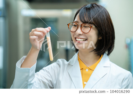 A woman in a white coat doing research 104016290