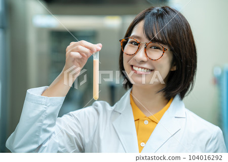 A woman in a white coat doing research 104016292