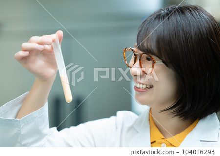 A woman in a white coat doing research 104016293