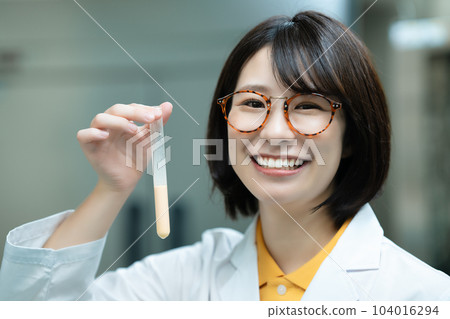 A woman in a white coat doing research A woman in a white coat doing research 104016294
