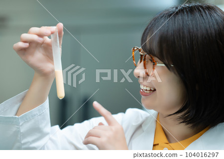 A woman in a white coat doing research A woman in a white coat doing research 104016297
