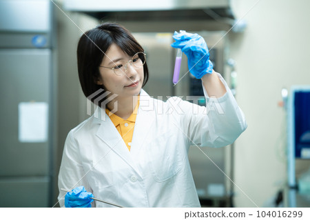A woman in a white coat doing research A woman in a white coat doing research 104016299