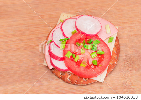 Crispy Cracker Sandwich with Tomato, Sausage, Cheese, Green Onions and Radish Crispy Cracker Sandwich with Tomato, Sausage, Cheese, Green Onions and Radish 104016318