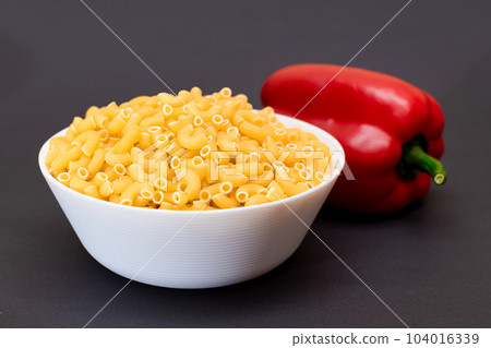 Uncooked Chifferi Rigati Pasta in White Cup and Red Bell Pepper Uncooked Chifferi Rigati Pasta in White Cup and Red Bell Pepper 104016339