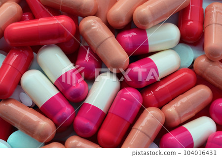Pills. Set of pills. Bottle and scattered pills on color background, top view. Space for text. Heap of medical pills in white, blue and other colors. Pills in plastic package. Pills. Set of pills. Bottle and scattered pills on color background, top view. Space for text. Heap of medical pills in white, blue and other colors. Pills in plastic package. 104016431