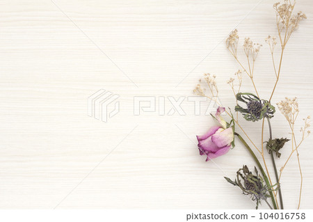 Pretty decorative frame with roses, eryngiums and hazy grass on light wooden background Pretty decorative frame with roses, eryngiums and hazy grass on light wooden background 104016758