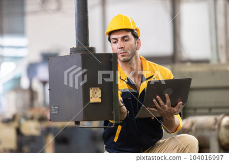 Industrial man engineer wear uniform and helmet using laptop are checking system machine at factory. Industrial man engineer wear uniform and helmet using laptop are checking system machine at factory. 104016997