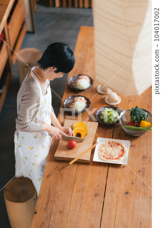 一位 50 多歲的女士在廚房做飯 104017002