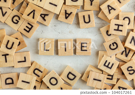 Top down view, pile of square wooden blocks with word LIE on white board. Top down view, pile of square wooden blocks with word LIE on white board. 104017261