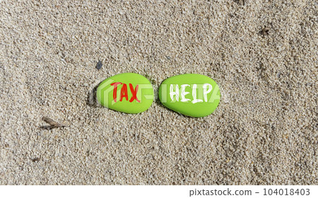 Tax help symbol. Concept words Tax help on beautiful green stone on a beautiful sand sea beach background. Business, support and tax help concept. Copy space. 104018403