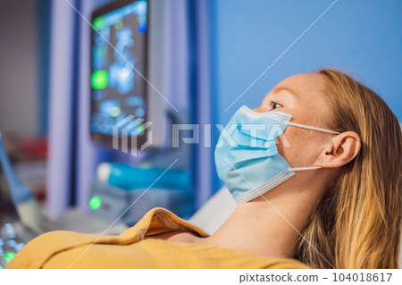 In the Hospital, Close-up Shot of the Doctor does Ultrasound Sonogram Procedure to a Pregnant Woman. Obstetrician Moving Transducer on the Belly of the Future Mother 104018617