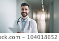 Hospital. Health care. Portrait of young smiling 30-year-old bearded caucasian man doctor wearing white medical coat with stethoscope around his neck, looking at camera. Hospital Corridor, AI 104018652