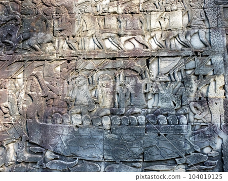 Ancient bas-reliefs illustrating historical and mythical subjects on the walls of the Khmer Bayon Temple. 104019125