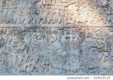 Photograph of ancient bas-reliefs on the Bayon Temple walls depicting historical and mythical themes, a Khmer marvel. Photograph of ancient bas-reliefs on the Bayon Temple walls depicting historical and mythical themes, a Khmer marvel. 104019126
