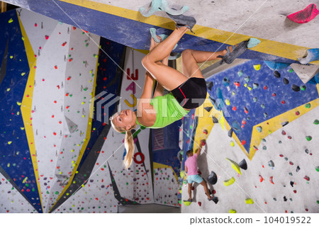 Female climbing artificial rock wall 104019522