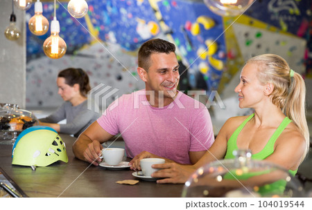 Climbers discussing over cup of coffee in sports bar at gym Climbers discussing over cup of coffee in sports bar at gym 104019544