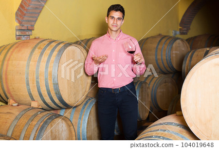 Man posing in winery cellar 104019648