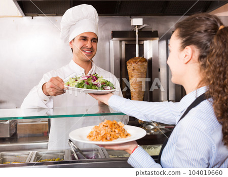 Waitress receiving order from chef 104019660