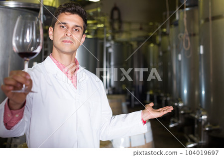Winery technician posing with wine 104019697