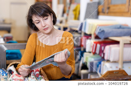 Woman looking for cloth in shop Woman looking for cloth in shop 104019726