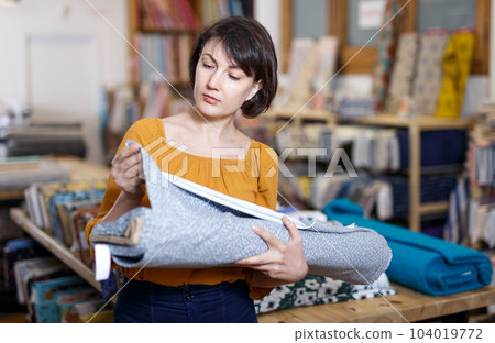 Woman looking for cloth in shop Woman looking for cloth in shop 104019772