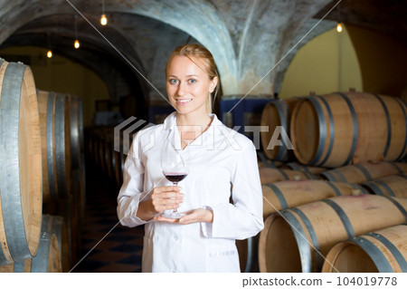 Female wine house worker checking quality of product Female wine house worker checking quality of product 104019778