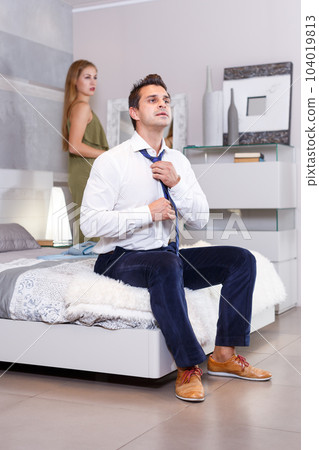 Man sitting on bed and dressing Man sitting on bed and dressing 104019813