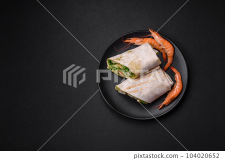 Delicious fresh roll with shrimps, tomatoes, lettuce and cucumber in pita bread 104020652