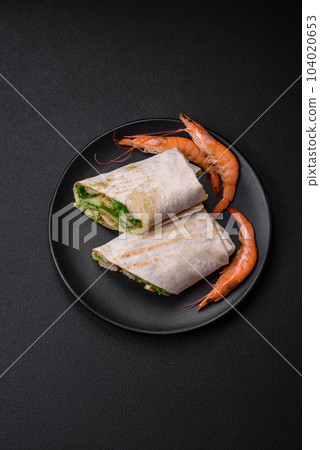 Delicious fresh roll with shrimps, tomatoes, lettuce and cucumber in pita bread 104020653