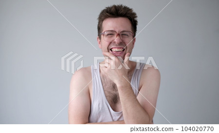 A sarcastic man in big glasses mockingly laughs and points his finger at the camera 104020770