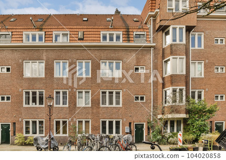 an apartment building with bicycles parked in the street next to each other buildings on a sunny day - stock photo 104020858