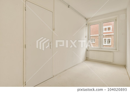 an empty room with white walls and flooring, there is a door leading to the left side of the room 104020893