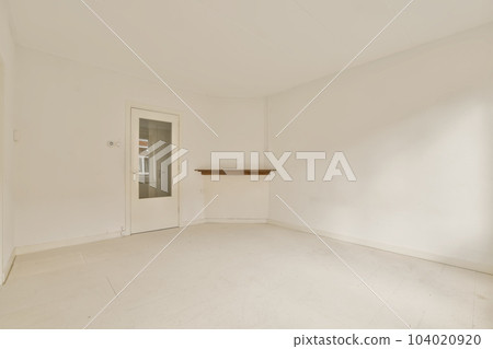 an empty living room with white walls and floor, there is a door leading to the left side of the room 104020920