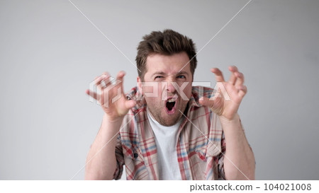 European young man frightens the interlocutor, says boo, and contorts his fingers European young man frightens the interlocutor, says boo, and contorts his fingers 104021008