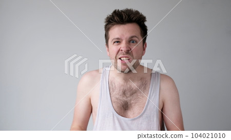 European young man behaves aggressively, contorts an angry face, and threatens someone European young man behaves aggressively, contorts an angry face, and threatens someone 104021010