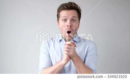 European young man is greatly surprised and opens his mouth in astonishment European young man is greatly surprised and opens his mouth in astonishment 104021020