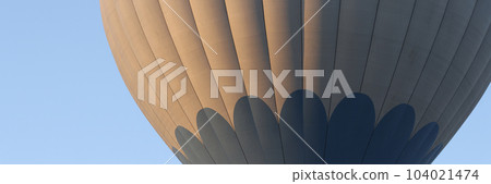 Hot air balloon flies on blue sky closeup Hot air balloon flies on blue sky closeup 104021474