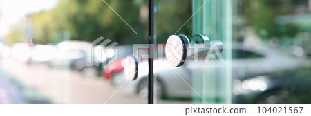 Stainless steel handle on glass door closeup Stainless steel handle on glass door closeup 104021567