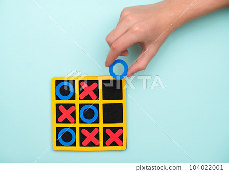A game of tic tac toe. Concept XO Win Challenge. Developmental game for children. Flat lay, top view. Business marketing strategy planning concept A game of tic tac toe. Concept XO Win Challenge. Developmental game for children. Flat lay, top view. Business marketing strategy planning concept 104022001