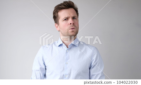 man listens to the news with disbelief and looks astonished into the camera man listens to the news with disbelief and looks astonished into the camera 104022030