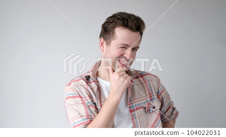 man is deep in thought, scratching his chin while trying to choose something 104022031