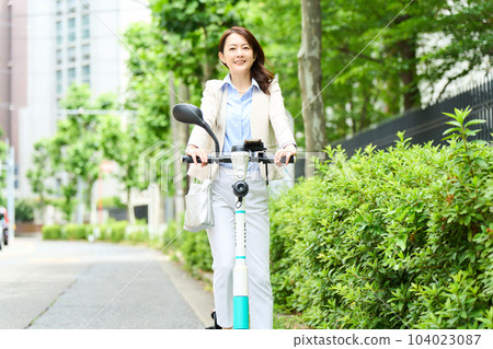 Female driving an electric kickboard Female driving an electric kickboard 104023087