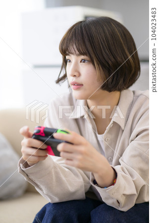 young woman playing video games young woman playing video games 104023483
