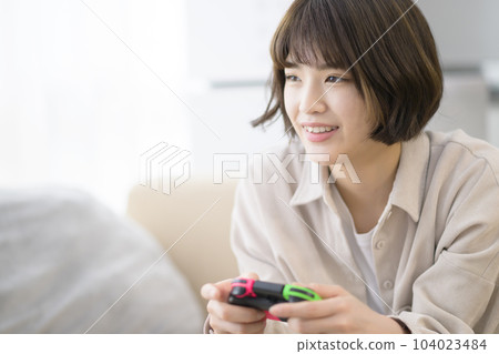 young woman playing video games young woman playing video games 104023484