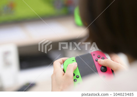 young woman playing video games young woman playing video games 104023485