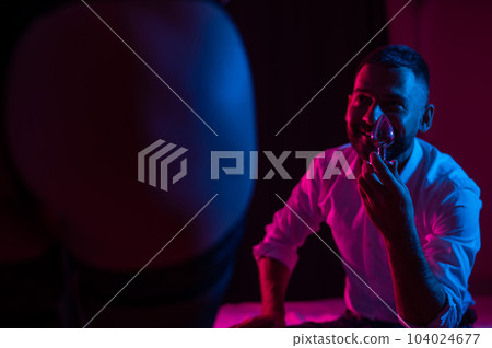 Bearded caucasian man holding an anal plug. Close-up of female buttocks in underwear. Sexual preferences of the couple. Bearded caucasian man holding an anal plug. Close-up of female buttocks in underwear. Sexual preferences of the couple. 104024677