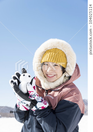 雪山堆雪人玩耍的年輕女子 104025114